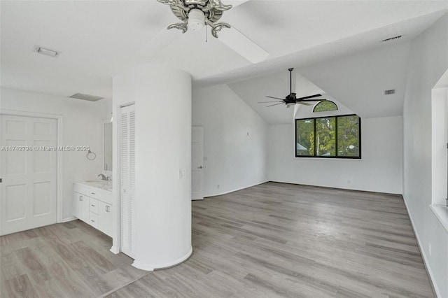 unfurnished living room with ceiling fan, lofted ceiling, sink, and light hardwood / wood-style floors