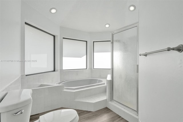 bathroom featuring hardwood / wood-style flooring, toilet, and separate shower and tub