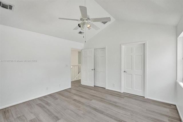 unfurnished bedroom with ceiling fan, lofted ceiling, and light hardwood / wood-style flooring