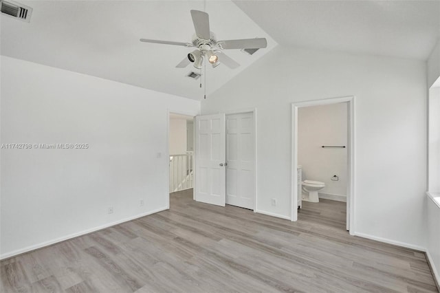 unfurnished bedroom featuring lofted ceiling, ensuite bath, light hardwood / wood-style floors, and ceiling fan