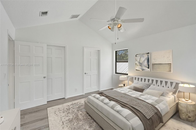 bedroom with ceiling fan, lofted ceiling, and light hardwood / wood-style floors