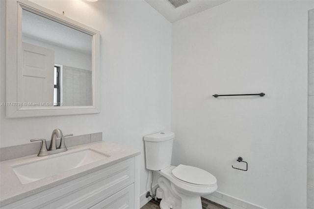 bathroom with hardwood / wood-style flooring, vanity, and toilet