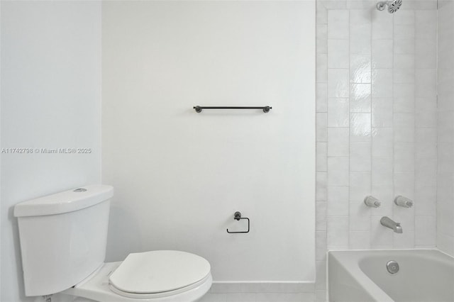 bathroom with tiled shower / bath, tile patterned floors, and toilet