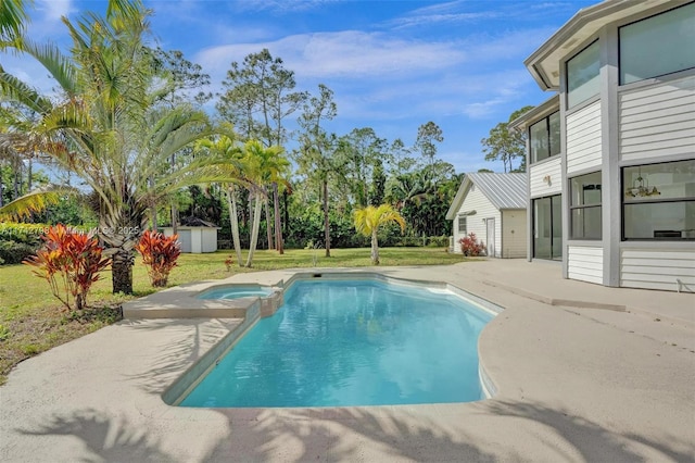 view of pool featuring an in ground hot tub, a yard, a shed, and a patio