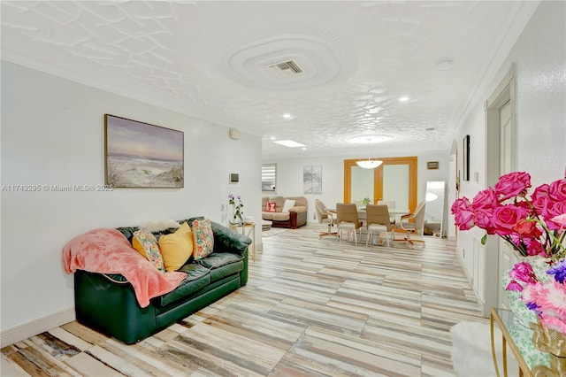 living room featuring visible vents, crown molding, and baseboards