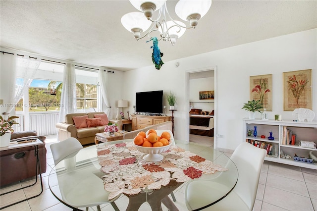 tiled dining area with a chandelier and a textured ceiling