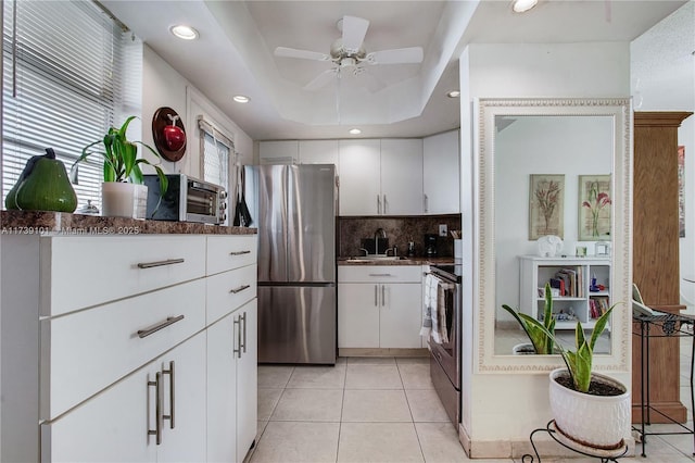 kitchen featuring white cabinetry, light tile patterned floors, a tray ceiling, and appliances with stainless steel finishes