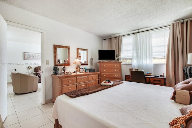 bedroom featuring light tile patterned floors and a textured ceiling