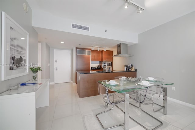 dining space with light tile patterned flooring, rail lighting, and sink