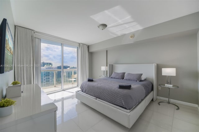 bedroom with access to outside, a wall of windows, and light tile patterned floors