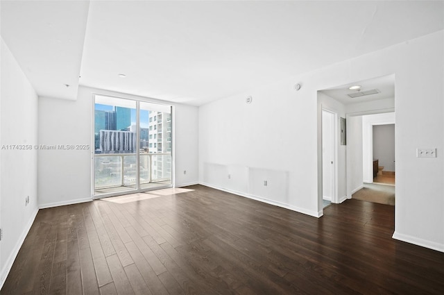 spare room with dark wood-type flooring and floor to ceiling windows