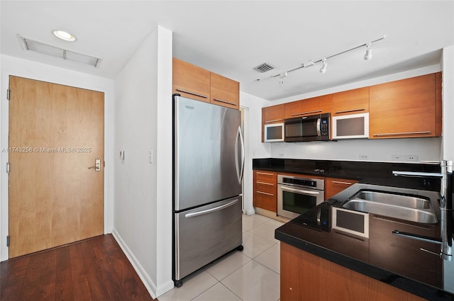 kitchen with light tile patterned floors, stainless steel appliances, and sink