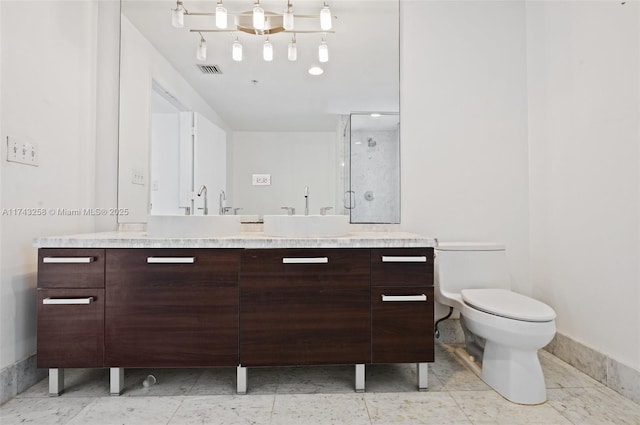 bathroom featuring vanity, a shower with door, and toilet