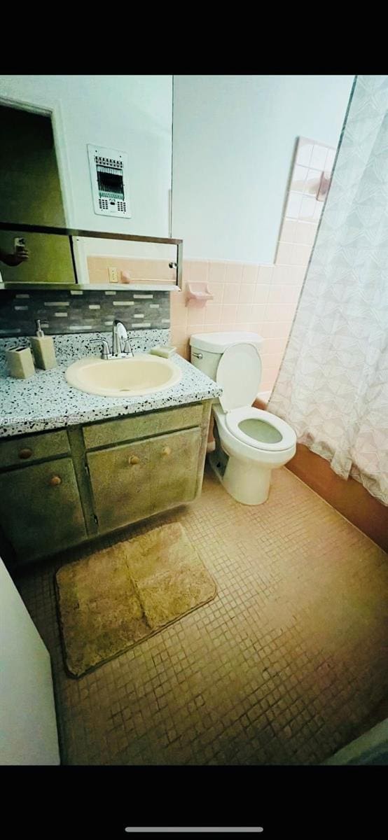 bathroom featuring tile patterned floors, vanity, toilet, and tile walls