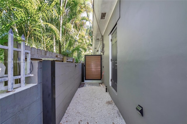 view of property exterior featuring fence, a gate, and stucco siding