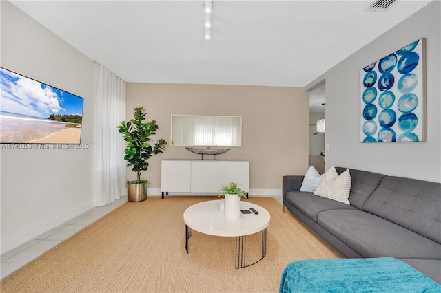 living area with light tile patterned floors, visible vents, and baseboards