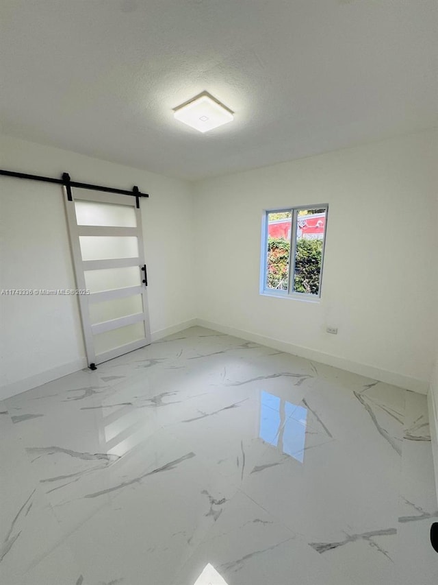 empty room featuring a barn door and a textured ceiling