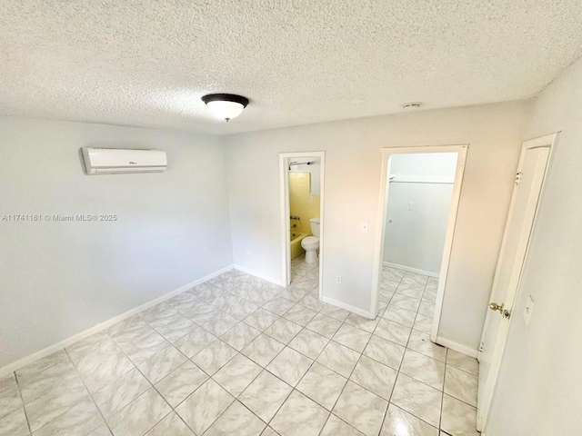 empty room with a wall unit AC and a textured ceiling