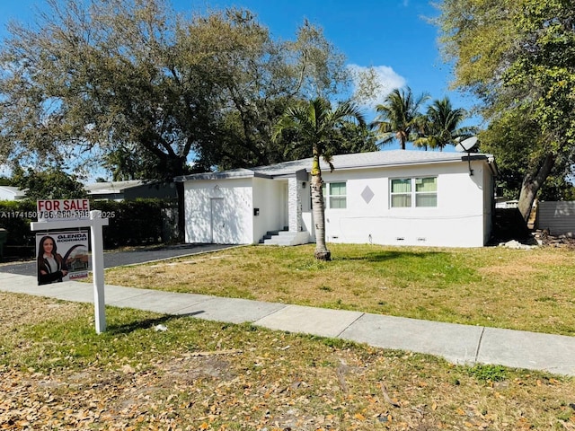 view of front facade featuring a front yard and stucco siding