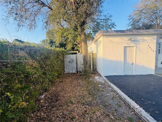 view of side of property with fence and stucco siding