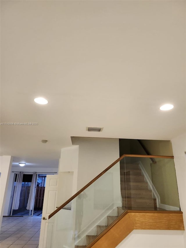 stairway featuring tile patterned flooring