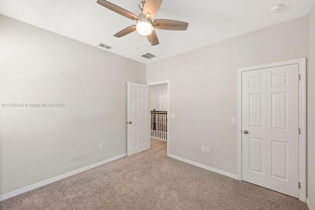 unfurnished bedroom with ceiling fan and light colored carpet