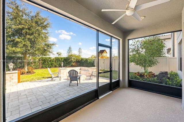 unfurnished sunroom with ceiling fan