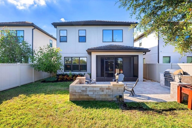 rear view of property featuring area for grilling, a yard, and a patio