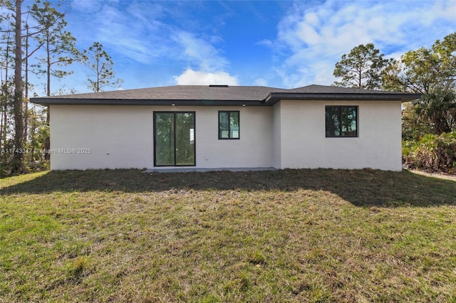 rear view of property with a lawn