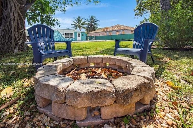 exterior details featuring an outdoor fire pit and fence