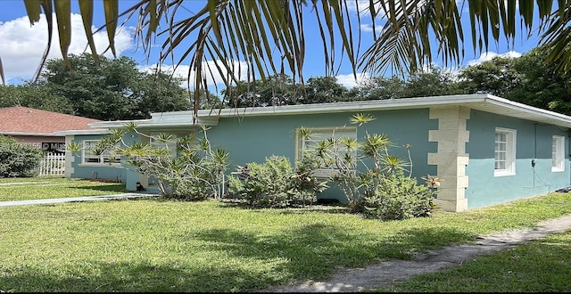 view of side of home featuring a yard and stucco siding