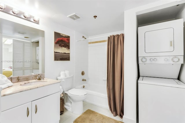 full bathroom featuring tile patterned flooring, vanity, stacked washer and clothes dryer, toilet, and shower / bath combo with shower curtain