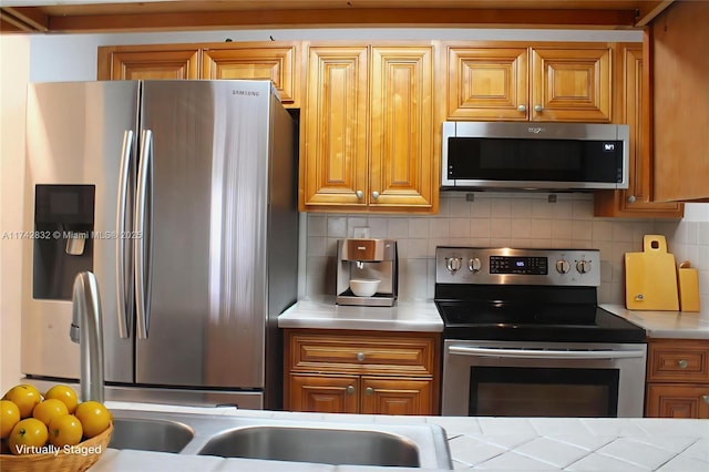 9455 W Flagler St Unit C409, Miami, FL 33174 - kitchen featuring stainless steel appliances, light countertops, backsplash, and brown cabinets
