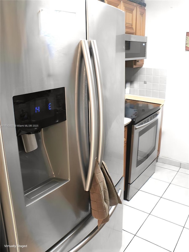 kitchen featuring appliances with stainless steel finishes, decorative backsplash, and light tile patterned floors