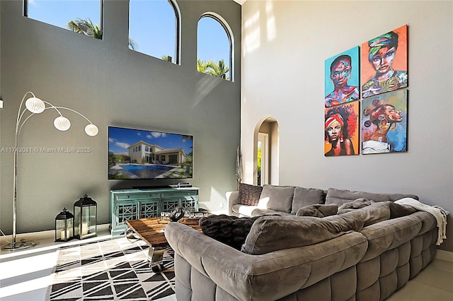 living room with a high ceiling and a healthy amount of sunlight