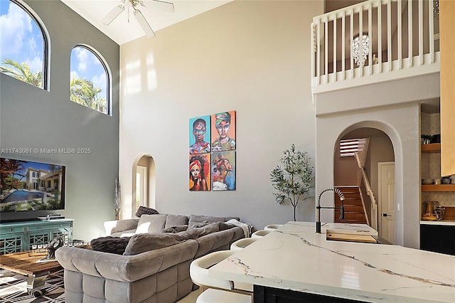 living room with sink, a towering ceiling, and ceiling fan