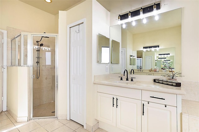 bathroom featuring vanity, a shower with shower door, and tile patterned floors