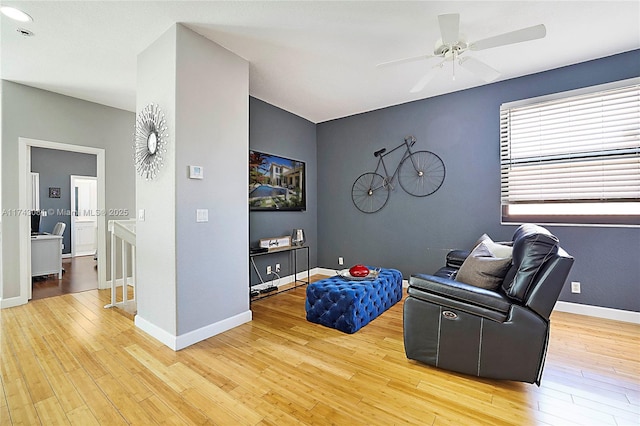 living area with ceiling fan and light hardwood / wood-style flooring