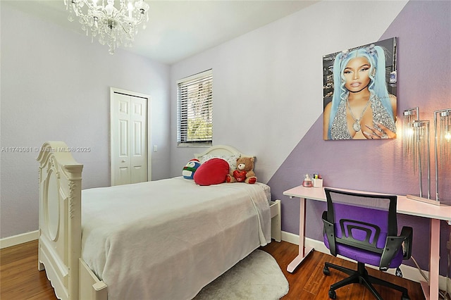 bedroom featuring an inviting chandelier, dark hardwood / wood-style flooring, and a closet