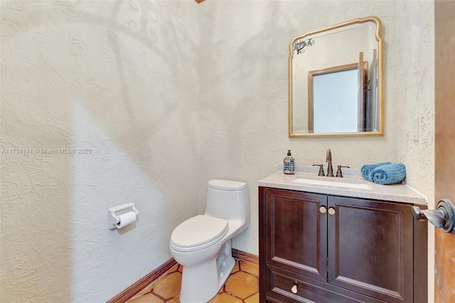 bathroom with tile patterned flooring, vanity, and toilet