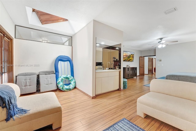 living room with light hardwood / wood-style floors and ceiling fan