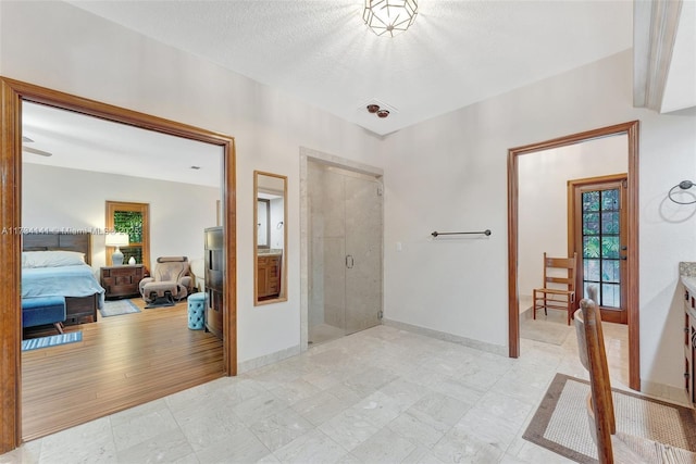 bathroom with vanity, a shower with door, and a textured ceiling