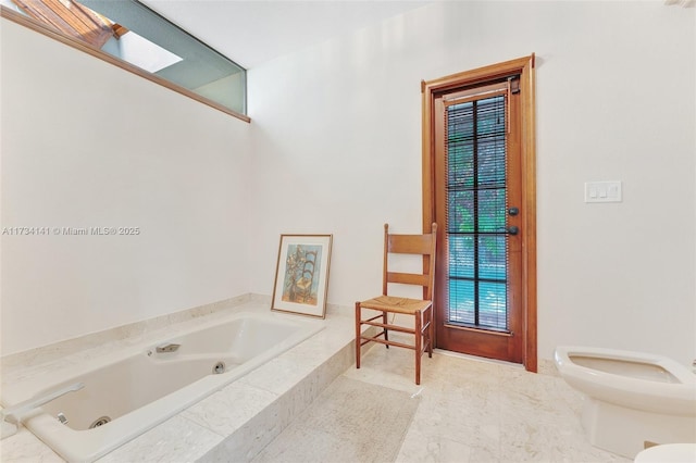 bathroom featuring a relaxing tiled tub and toilet