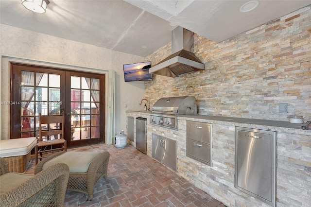 kitchen with french doors, refrigerator, sink, and wall chimney range hood