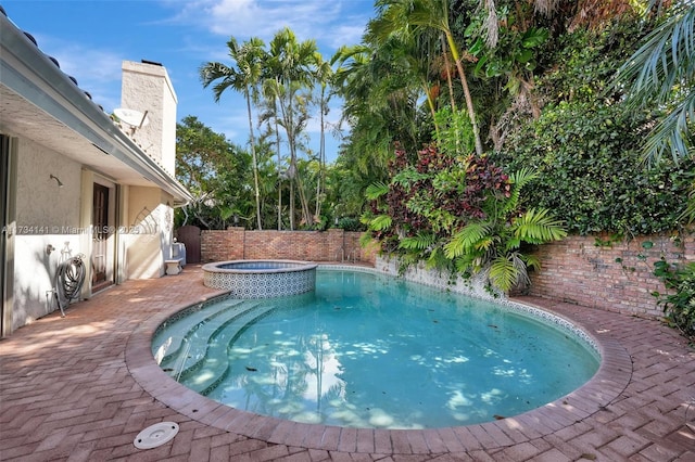 view of swimming pool featuring an in ground hot tub and a patio