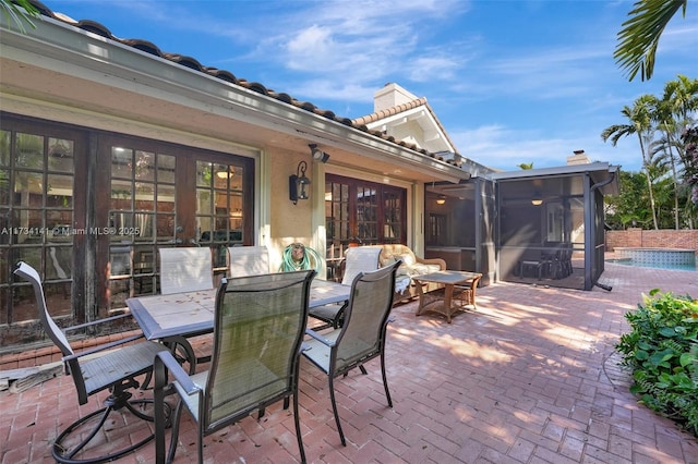 view of patio featuring french doors and a sunroom