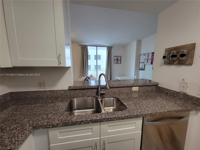 kitchen featuring white cabinetry, sink, dark stone counters, stainless steel dishwasher, and kitchen peninsula