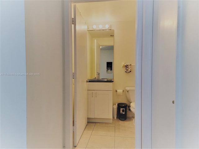 corridor featuring sink and light tile patterned floors