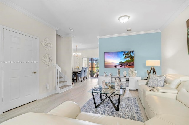 living room featuring an inviting chandelier, crown molding, and light wood-type flooring