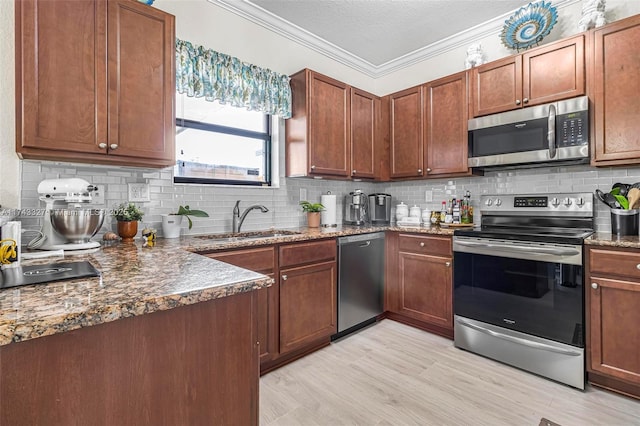 kitchen with sink, decorative backsplash, ornamental molding, stainless steel appliances, and a textured ceiling